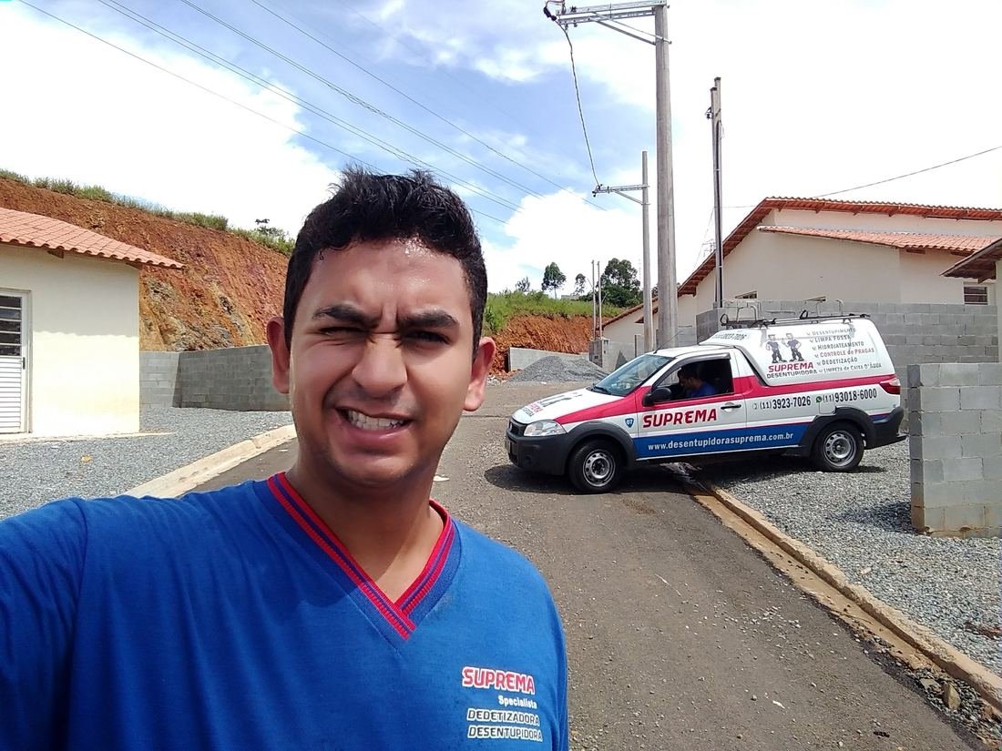 Técnico da Suprema Desentupidora ao lado do veículo de atendimento